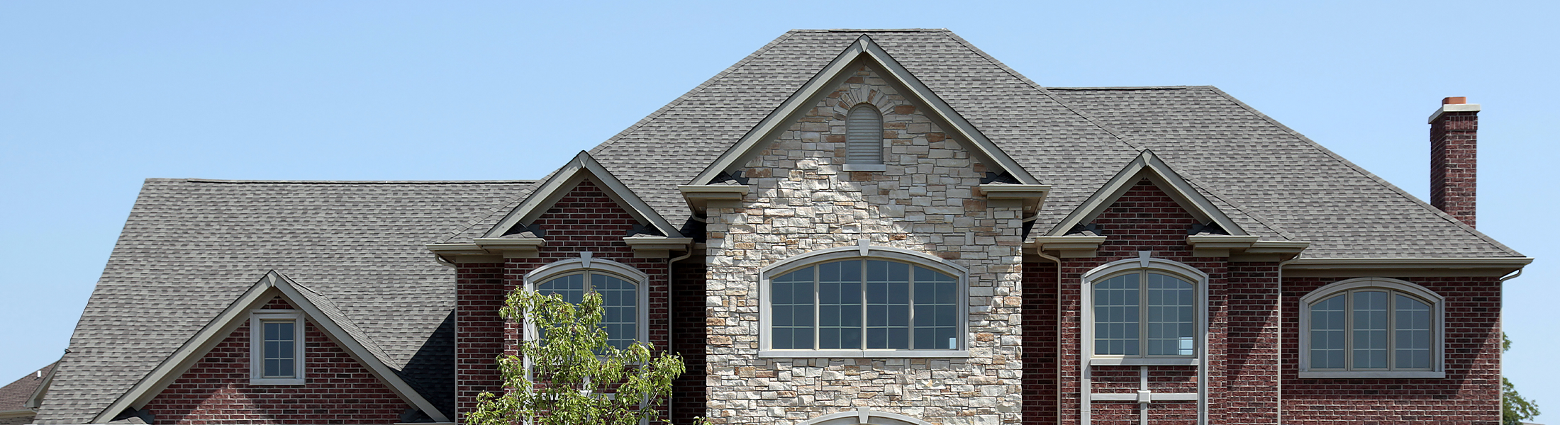 Brick home with a gray shingle roof